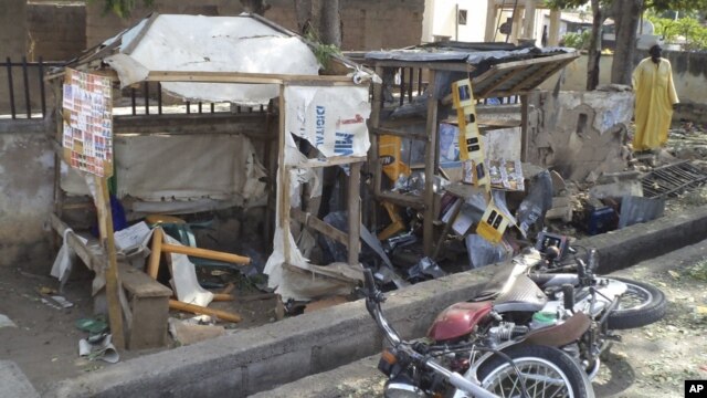 A man inspects the wreckage following a suicide bomb attack on a street in Jalingo, Nigeria, April 30, 2012.