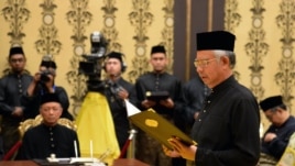 Malaysia's Prime Minister Najib Razak (R) reads his oath declaration as he is sworn in for his second term as prime minister, May 6, 2013.