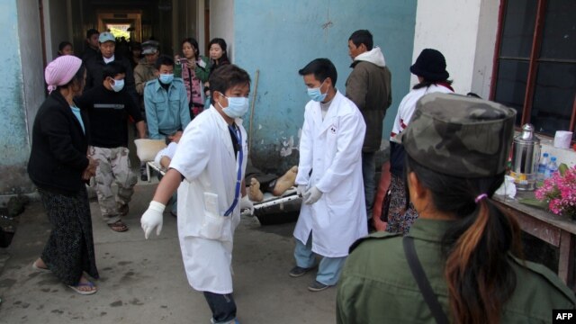 Medical staff at the Laiza hospital carry a man on a stretcher after he was injured during an artillery attack by the Burmese military in the town of Laiza, January 14, 2013. 