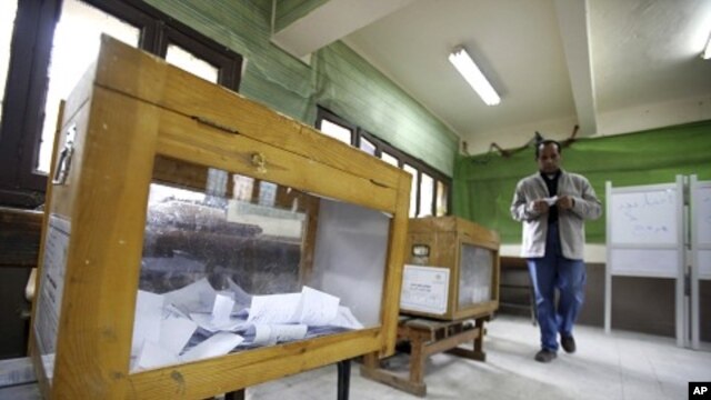 A man prepares to cast his vote during the second day of the parliamentary runoff elections at a polling station in Cairo, December 6, 2011.