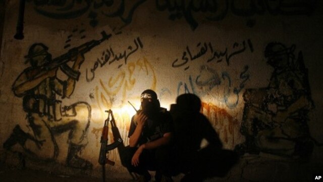 A Palestinian militant member of the Qassam Brigades, Hamas' armed wing, talks on a walkie-talkie at Rafah refugee camp, southern Gaza strip, August 21, 2011