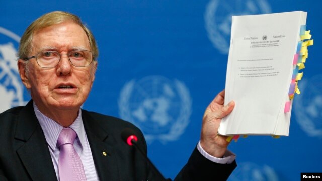 Michael Kirby, Chairperson of the Commission of Inquiry on Human Rights in North Korea holds a copy of his report during a news conference at the United Nations in Geneva on February 17, 2014. 