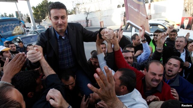 Ahmed Safadi, who won a seat in parliamentary elections, celebrates with his supporters in Amman, Jordan, January 24, 2013.