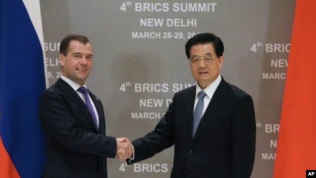 Russia's President Dmitry Medvedev (L) shakes hands with his Chinese counterpart Hu Jintao during their bilateral meeting in New Delhi, March 28, 2012. 