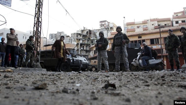 Residents and Lebanese army soldiers inspect damage following days of clashes between Sunni Muslims and Alawites in the port-city of Tripoli, northern Lebanon, December 10, 2012. 