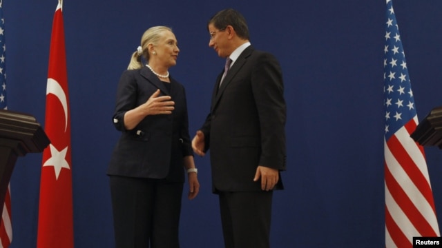 U.S. Secretary of State Hillary Clinton and Turkish Foreign Minister Ahmet Davutoglu talk after their news conference in Istanbul, Turkey, August 11, 2012.