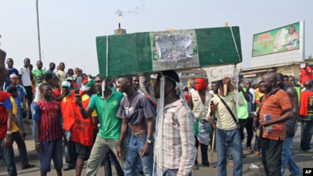 A man carries a coffin as protesters march through a road on the third day of a protest against a removal of fuel subsidies in Nigeria's commercial capital Lagos, January 11, 2012.