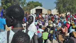 FILE - Women wait for grain to feed their families, at Doro refugee camp in South Sudan.