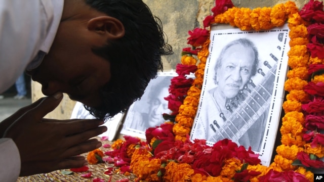 A student pays tribute to legendary Indian sitar player Ravi Shankar at the Bengali Tola Inter College, where Shankar had studied in Varanasi, India, Dec. 12, 2012. 