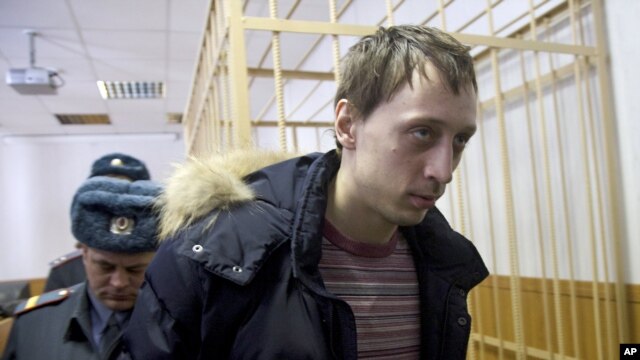 Pavel Dmitrichenko, foreground, is escorted out of a courtroom in Moscow, March 7, 2013. 