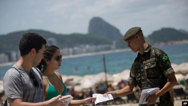 Một người lính phân phát những cuốn sách chứa những thông tin về muỗi Aedes aegypti tại các bãi biển ở Copacabana, Rio de Janeiro, 13/2/2016.