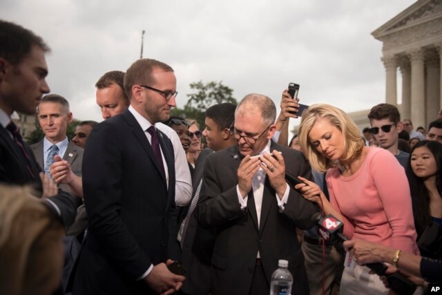 Jim Obergefell, the named plaintiff in the case before the Supreme Court, center, talks on a cellphone to President Barack Obama on the steps of the Supreme Court following the court's decision, in Washington, D.C., June 26, 2015.