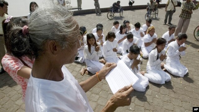 FILE - Rape victims who never received hearings for allegations pray in front of Royal Palace, Phnom Penh, Cambodia.