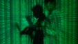 FILE - An illustration picture shows a projection of binary code on a man holding a laptop computer.