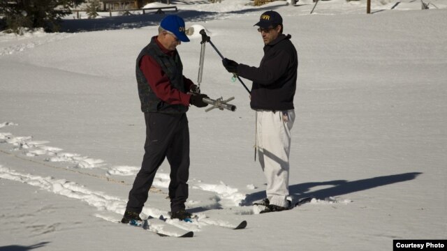 Frank Gehrke (kanan), kepala program survei salju mengukur tumpukan salju di Gunung Sierra Nevada, California. (Foto: California Dept. of Water Resources)