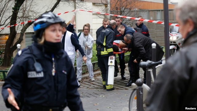 Nhân viên cứu hỏa đưa một nạn nhân ra khỏi hiện trường sau vụ nổ súng tại tòa soạn tuần báo Charlie Hebdo ở Paris, ngày 7/1/2015.