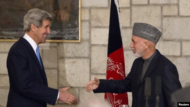 Ngoại trưởng Kerry (trái) bắt tay với Tổng thống Afghanistan Hamid Karzai vào cuối buổi họp báo chung tại dinh tổng thống ở Kabul, 25/3/2013.