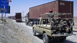 Paramilitary soldiers escort a convoy of trucks carrying supplies for NATO troops in Afghanistan, before crossing into Afghanistan from Pakistan, July 16, 2012.