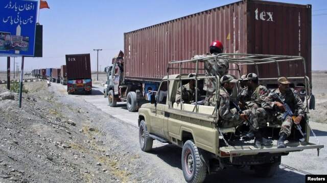 Paramilitary soldiers escort a convoy of trucks carrying supplies for NATO troops in Afghanistan, before crossing into Afghanistan from Pakistan, July 16, 2012.