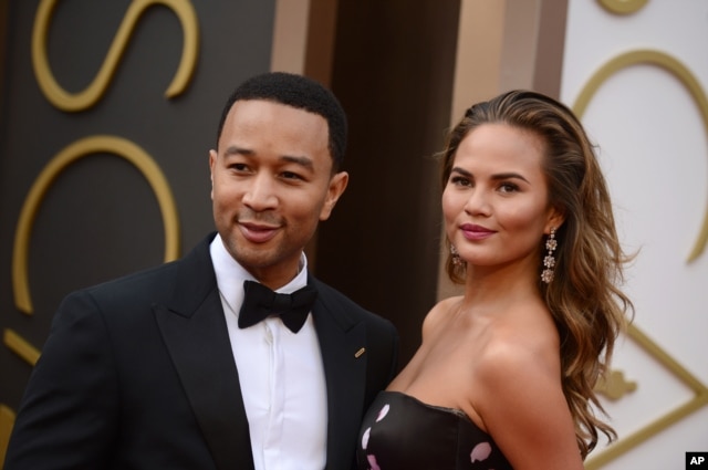 John Legend, left, and Christine Teigen arrive at the Oscars on March 2, 2014, at the Dolby Theatre in Los Angeles.
