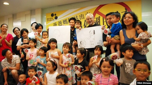 小朋友手持印有「停」字的波板(球拍)糖，呼籲當局停止洗腦式國民教育