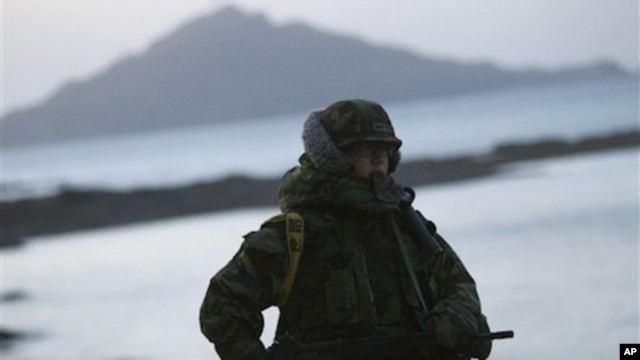 A South Korean marine mans a check point along the coast of South Korea's Yeonpyeong Island Sunday, Nov. 28, 2010.