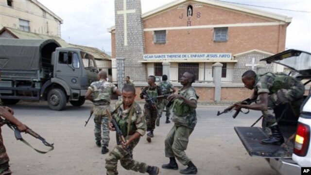 Government military officers run outside the air force base near the airport in Antananarivo, Madagascar, 20 Nov 2010