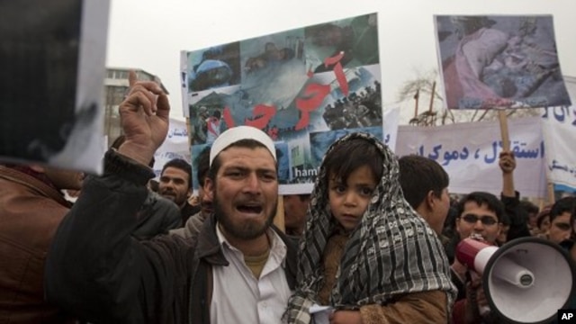 An Afghan man and his son take part in a protest in Kabul, March 6, 2011