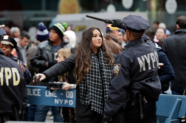 A New York Police Department officer searches a woman as she enters the Times Square, Dec. 31, 2015. Around 1 million people are expected to converge on Times Square for the annual New Year's Eve celebration.