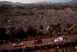 Paus Fransiskus dalam kendaraan 'Popemobile' (kanan) menyapa warga yang menyambut kedatangannya di Bolivia, Rabu (8/7)