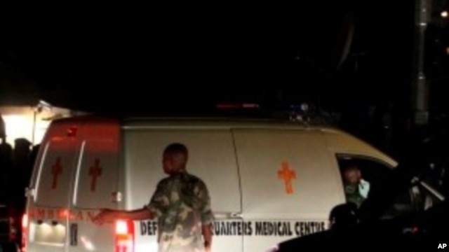 A soldier stands near an ambulance carrying victims of a bomb blast near a military barracks in Nigeria's capital Abuja, 31 Dec 2010