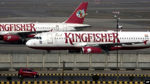 A car moves past Kingfisher Airlines aircraft parked at the airport in New Delhi February 21, 2012.