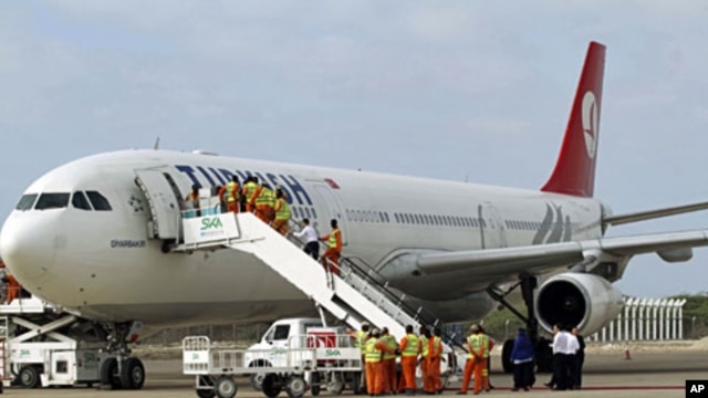 Employees work on a Turkish Airlines plane after its arrival at Aden Abdulle International Airport in Somalia's capital Mogadishu, March 6, 2012