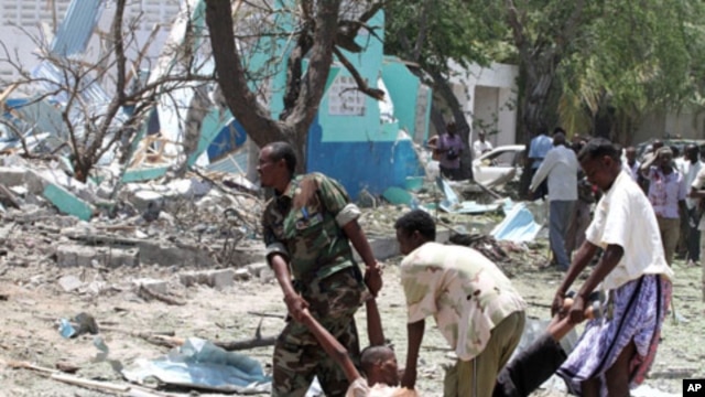 Somalia government soldiers carry a man killed during a suicide attack in Somalia's capital, Mogadishu, October 4, 2011.
