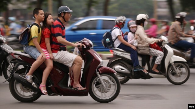 Trẻ em đi xe không đội mũ bảo hiểm tại Hà Nội.