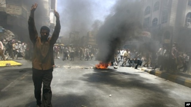 An anti-government protester flashes the victory sign during a demonstration to demand the ouster of Yemen's President Ali Abdullah Saleh in the southern city of Taiz May 12, 2011.