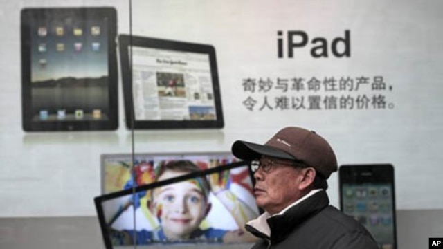 A man stands near Apple's iPad advertisement in Shanghai, China, Jan. 26, 2011