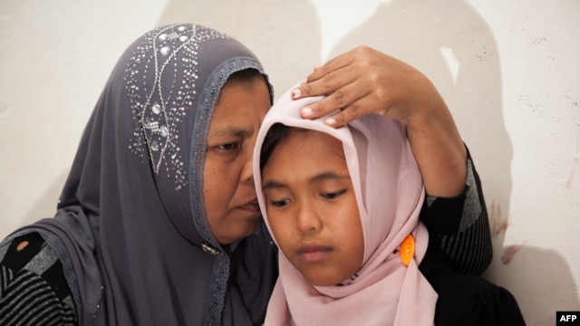 Indonesian mother Jamaliah (L) hugs her daughter Raudhatul Jannah (R) after they were reunited in Meulaboh, Aceh province, August 7, 2014.