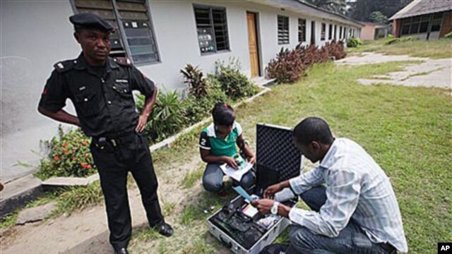 A police officer provides security as Electoral Officials check voter registration material and election equipment at a distribution center in Lagos, Nigeria, 15 Jan, 2011