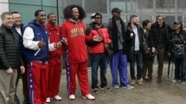 Flamboyant former NBA star Dennis Rodman, fifth from right, poses with three members of the Harlem Globetrotters basketball team, Pyongyang Airport, North Korea, Feb. 26, 2013.