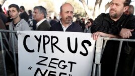 Protesters stand during parliamentary vote on a bank tax plan March 19, 2013 in Nicosia