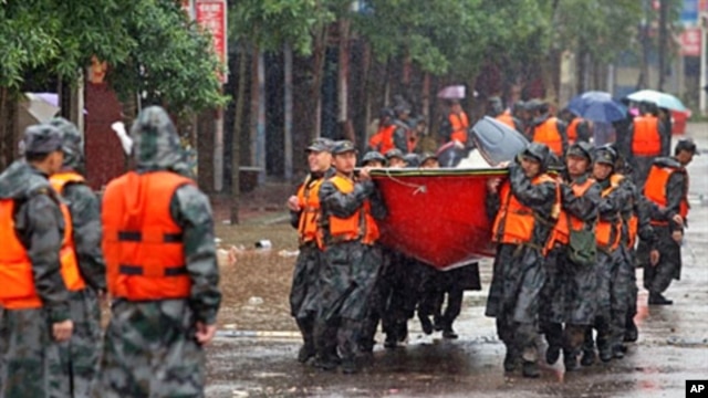 Chinese rescuers carry their boats in to evacuate residents in Fuzhou, Jiangxi province, 24 Jun 2010