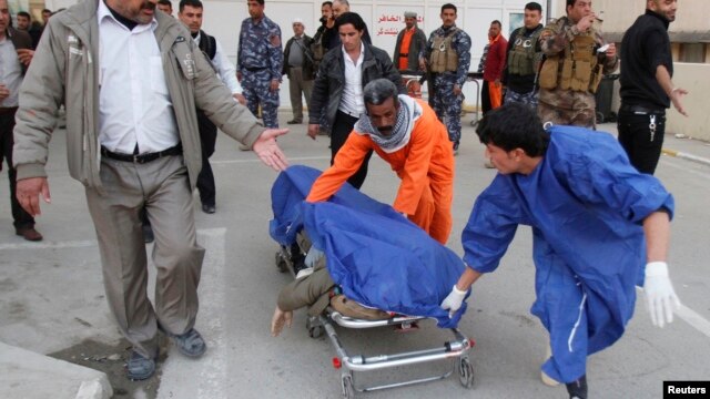Medical personnel wheel body of victim killed by suicide bomber in Tuz Khurmato city, Jan. 23, 2013