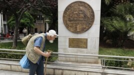 A man makes his way past a replica of a one drachma coin outside the Athens Town Hall, May 21, 2012.