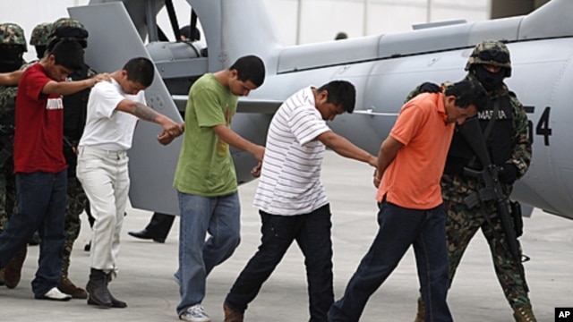 Alleged members of the Zetas cartel are escorted by members of the military as they are presented to the press after their arrests in Mexico City, Oct. 7, 2011.