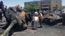An image from Edlib News Network shows citizens looking at a Syrian tank destroyed during clashes between rebels and Syrian government forces in Idlib province, June 4, 2012. (The photo cannot be independently confirmed)