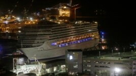 Ana jan jirgin ruwan fasinja na Carnival Triumph zuwa cikin tashar ruwan Mobile, Alabama, daren Alhamis 14 Fabrairu, 2013. 