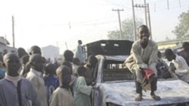 Wani yaro yake zaune kan wata motar 'Yansanda da aka kona, a wani hari da 'yan bindiga suka kai a jihar Kano.