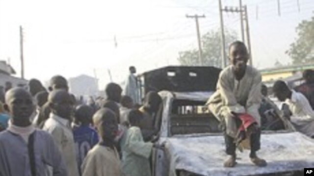 Wani yaro yake zaune kan wata motar 'Yansanda da aka kona, a wani hari da 'yan bindiga suka kai a jihar Kano.