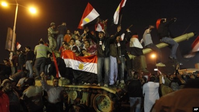 Egyptian citizens stand on an Egyptian military tank as they celebrate after President Hosni Mubarak resigned and handed power to the military at Tahrir Square in Cairo, Egypt, February 11, 2011